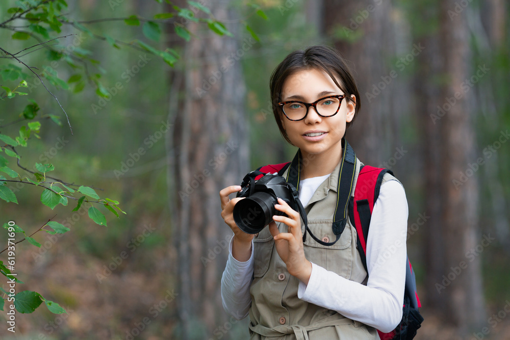 Girl naturalist with a camera in the forest. Girl naturalist with a camera in the forest.