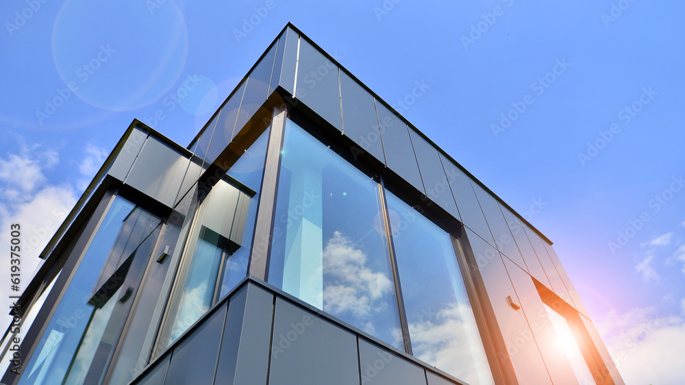 Graphite facade and large windows on a fragment of an office building against a blue sky. Modern aluminum cladding facade with windows. - obrazy, fototapety, plakaty 
