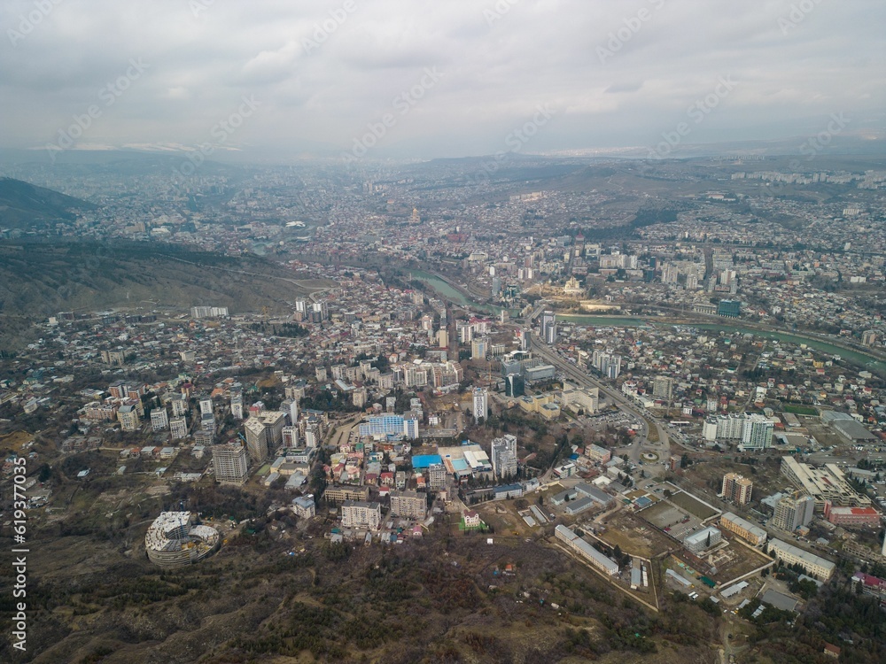 Aerial shot of the cityscape of Tbilisi, Georgia with buildings against a clouded sky