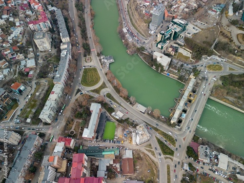 Aerial shot of the Kura river in Tbilisi, Georgia between the urban buildings