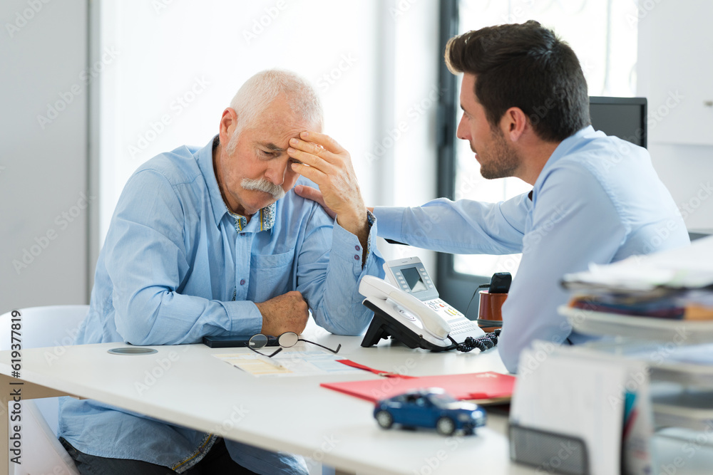 sad older worker and younger one talking in office sad older worker and younger one talking in office