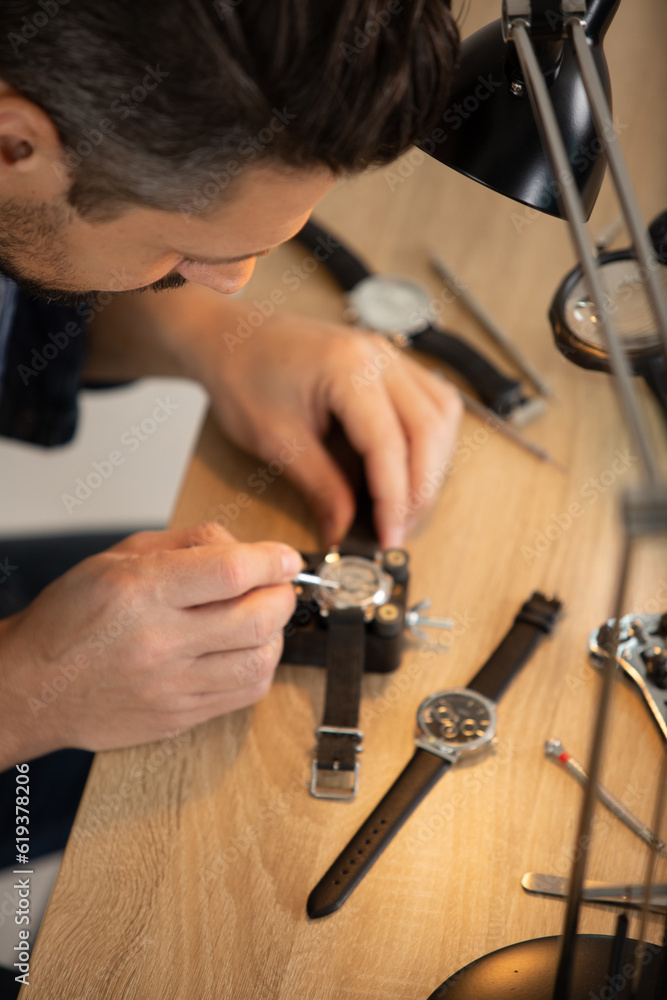 male clockmaker repairing wrist watch