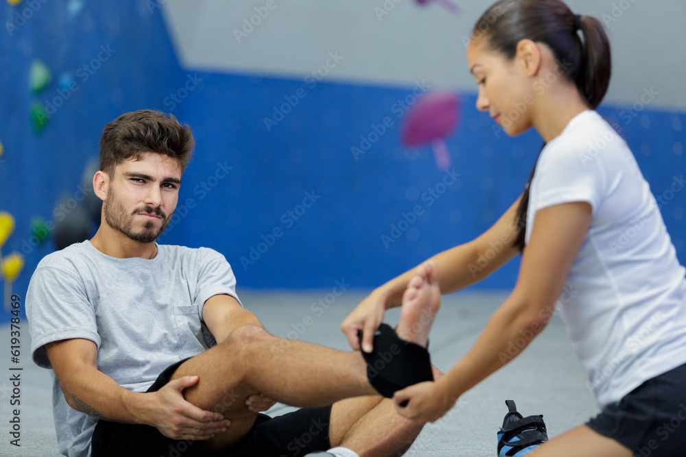 healthy man with an injured leg sitting in the gym healthy man with an injured leg sitting in the gym