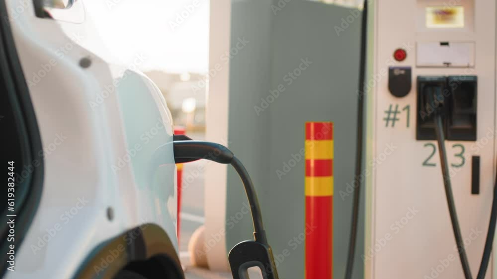 Electric car with plug cord connected to charging port. Electric car