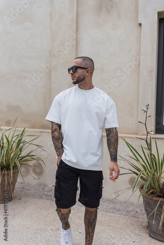 Chico tatuado con cuerpo estilizado posando con ropa contemporanea