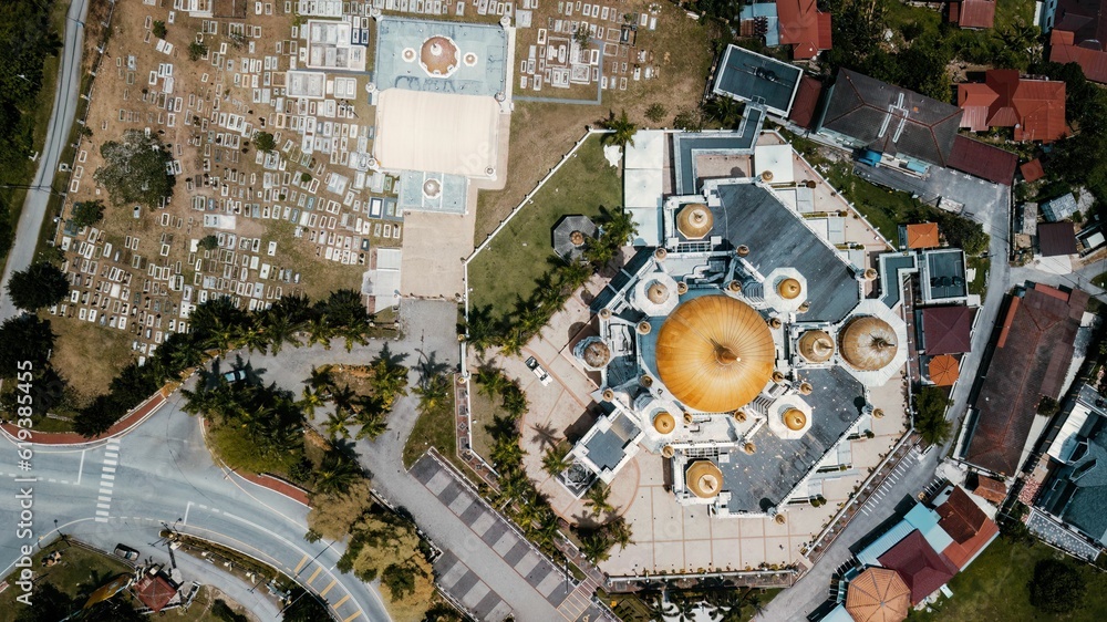 Aerial view of a bright yellow dome structure among the various buildings in Kuala Kangsar, Malaysia