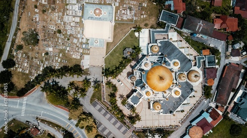 Aerial view of a bright yellow dome structure among the various buildings in Kuala Kangsar, Malaysia
