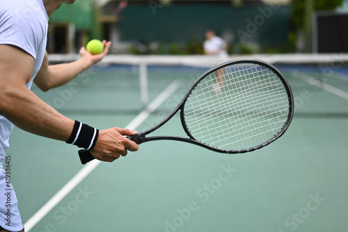 Tennis player serving tennis ball during a match on open court. Sport, training and active life concept