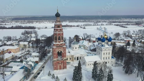 Scenic view from drone of temple complex of Cathedral of Archangel Michael and Church of Jerusalem Icon of Mother of God with Bronnitsy cityscape on background in winter, Russia