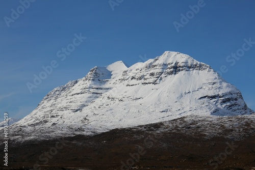 Landscape of the Torridon mountain covered in snow under a blue sky in Scotland