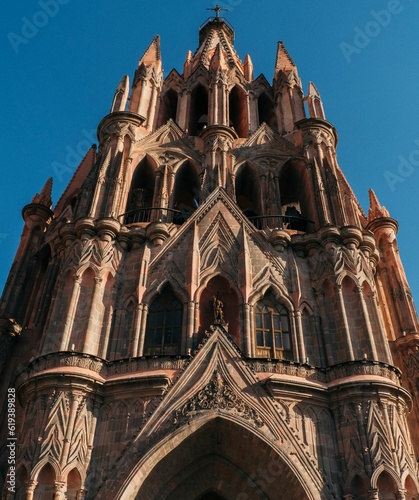 Vertical low-angle of the Parroquia de San Miguel Arcangel church in Mexico against the blue sky photo