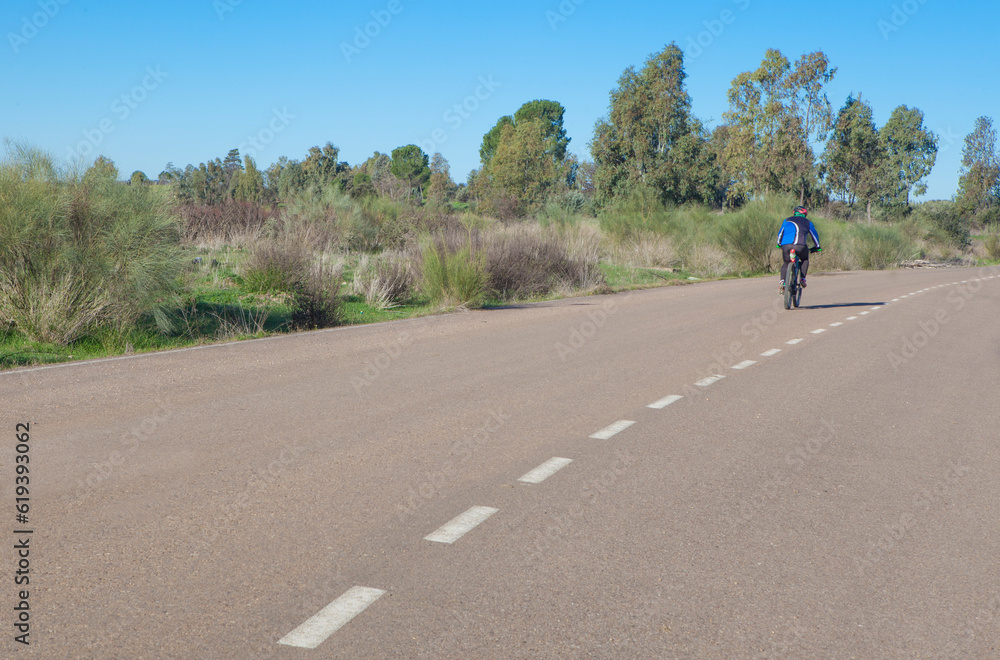 MTB Cyclist speeding down by local road. Vegas Altas irrigation channel roads