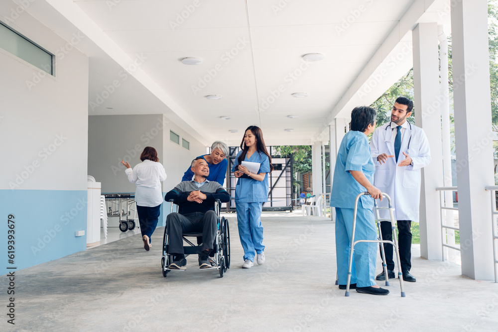Asian young doctor taking care and talking mature female patient sitting on wheelchair in hospital. Healthcare concept. Asian young doctor taking care and talking mature female patient sitting on wheelchair in hospital. Healthcare concept.