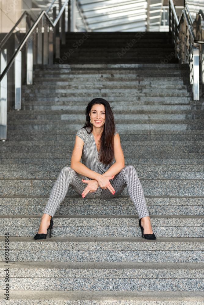 Full length portrait of a young joke sitting on the stairs outdoors