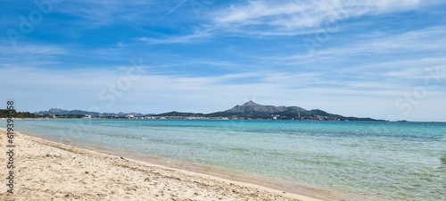 Fototapeta Naklejka Na Ścianę i Meble -  Sandy beach and crystal clear, blue waters lapping against the shore. Alcudia, Balearic Islands.