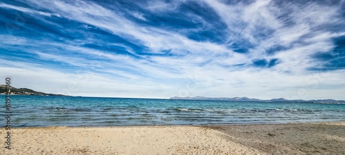Beautiful blue sky with white clouds above a sandy beach and sea.