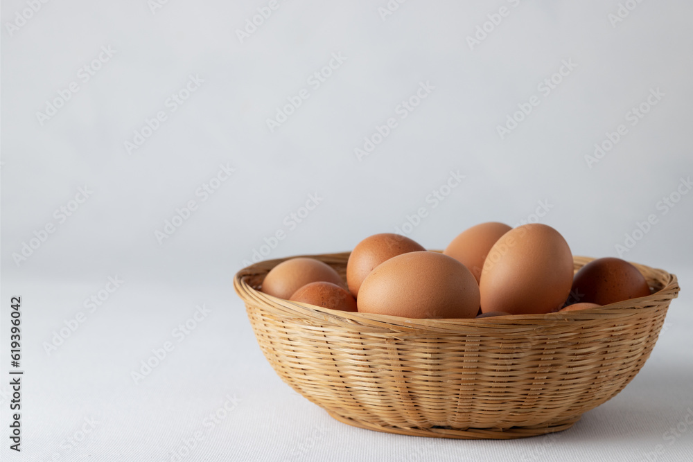 A few eggs with a brown shell in a wicker basket on a white background. White space A few eggs with a brown shell in a wicker basket on a white background. White space