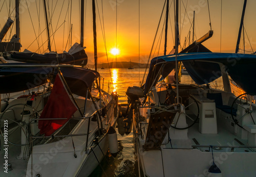 Fototapeta Naklejka Na Ścianę i Meble -  Yachts and luxury boats at Poros island in Greece against the sunset. Golden hour.
