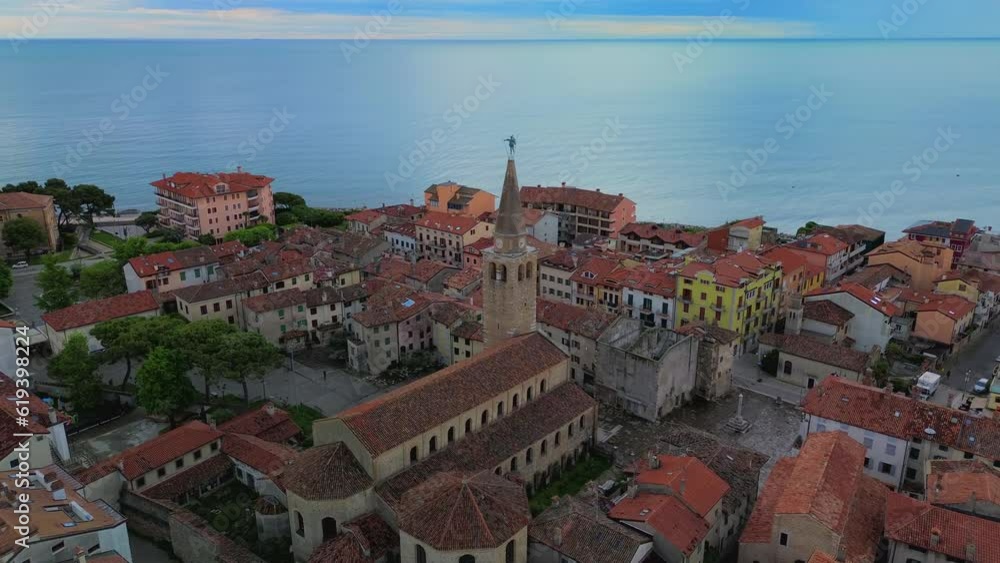 Aerial view of the old city. Roofs of buildings with red tiles and many chimneys. The bell tower of the Catholic Cathedral in the city center. Traveling through narrow streets. Italy Grado 07.2023 Aerial view of the old city. Roofs of buildings with red tiles and many chimneys. The bell tower of the Catholic Cathedral in the city center. Traveling through narrow streets. Italy Grado 07.2023
