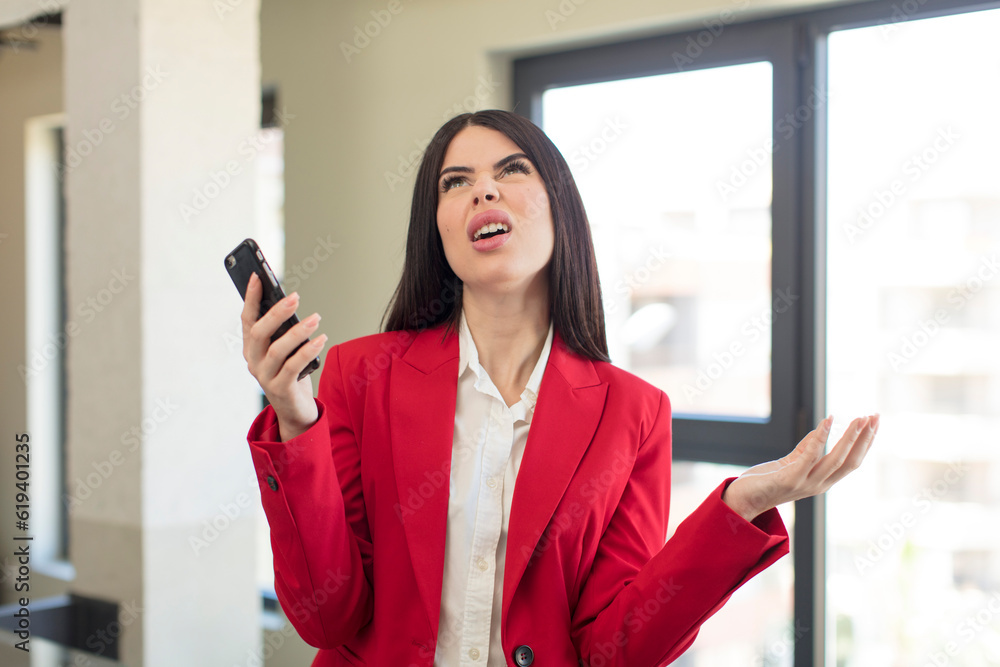 pretty young woman screaming with hands up in the air. smartphone concept pretty young woman screaming with hands up in the air. smartphone concept