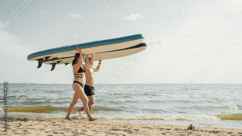 Summer lake friends go on vacation on the weekend. Dressed in bathing clothes. Young people surf an active lifestyle, go for a ride on the sup board. © muse studio