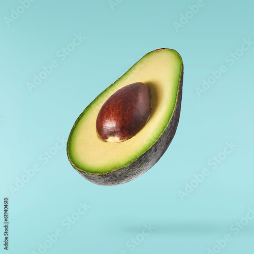 Fresh ripe avocado falling in the air isolated photo