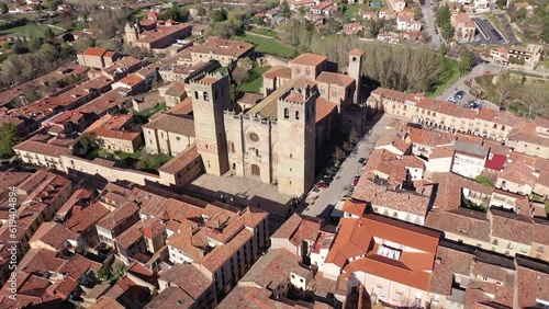 Aerial view of medieval Roman Catholic Catedral de Santa Maria in small Spanish city of Siguenza towering over residential buildings with brownish tiled roofs on spring day, province of Guadalajara photo