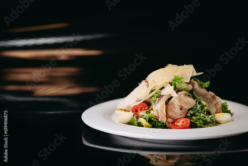 Caesar salad with chicken on a black background