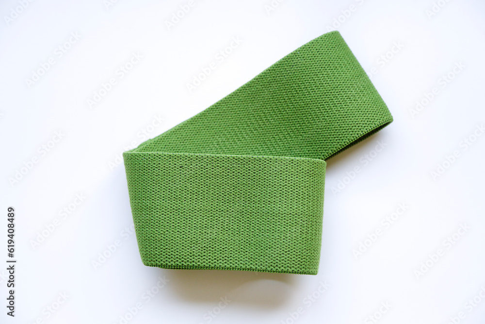 Fototapeta premium Sports equipment. Green elastic band for fitness.