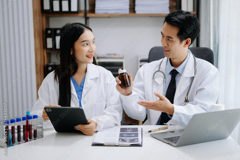 Obraz premium Medical technology network team meeting concept. Asian Doctor hand working with smart phone modern digital tablet and laptop computer with graphics chart interface,