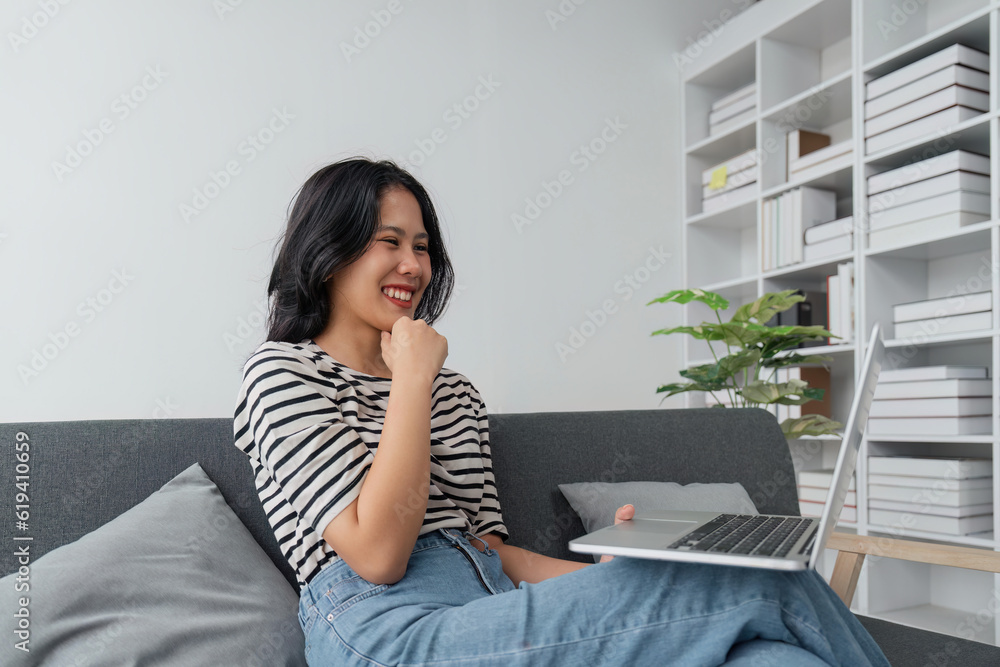Thoughtful young woman using computer while sitting on the sofa surfing the net at home Thoughtful young woman using computer while sitting on the sofa surfing the net at home