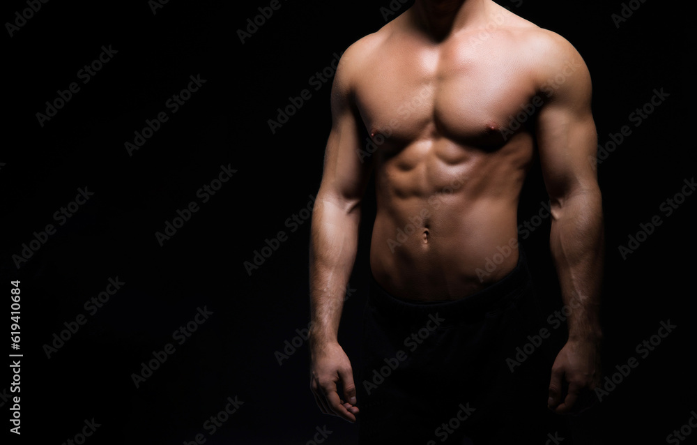 Strong, fit and sporty bodybuilder man over black background