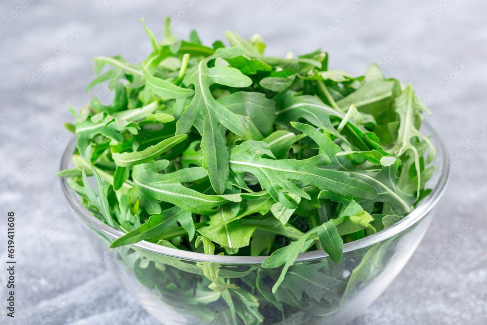 Rocket salad or arugula leaves in glass bowl, horizontal Rocket salad or arugula leaves in glass bowl, horizontal