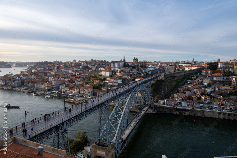 La belleza de Oporto, Portugal, con el icónico Puente Don Luis como protagonista. En la imagen, el puente de hierro se extiende majestuosamente sobre el río Duero, conectando las dos orillas de la ciu