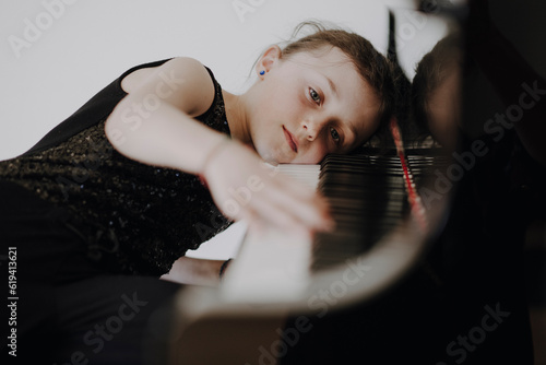 Photos Elegantes Mädchen sitzt am Konzertflügel und spielt Klavier