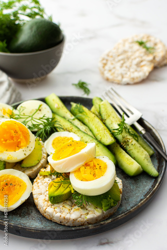 Healthy breakfasts, rice cakes with avocado and boiled eggs with dill and cucumber with spices, healthy wholesome food