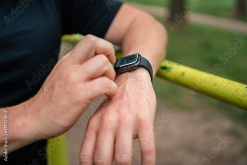 Close-up of man hand with smartwatch during outdoors workout, health and sport tracking 