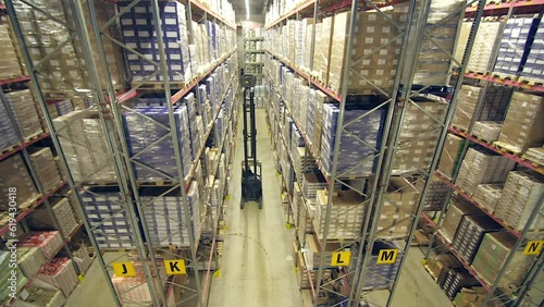 static timelapse wide shot of reach trucks working in a warehouse with very high ceilings