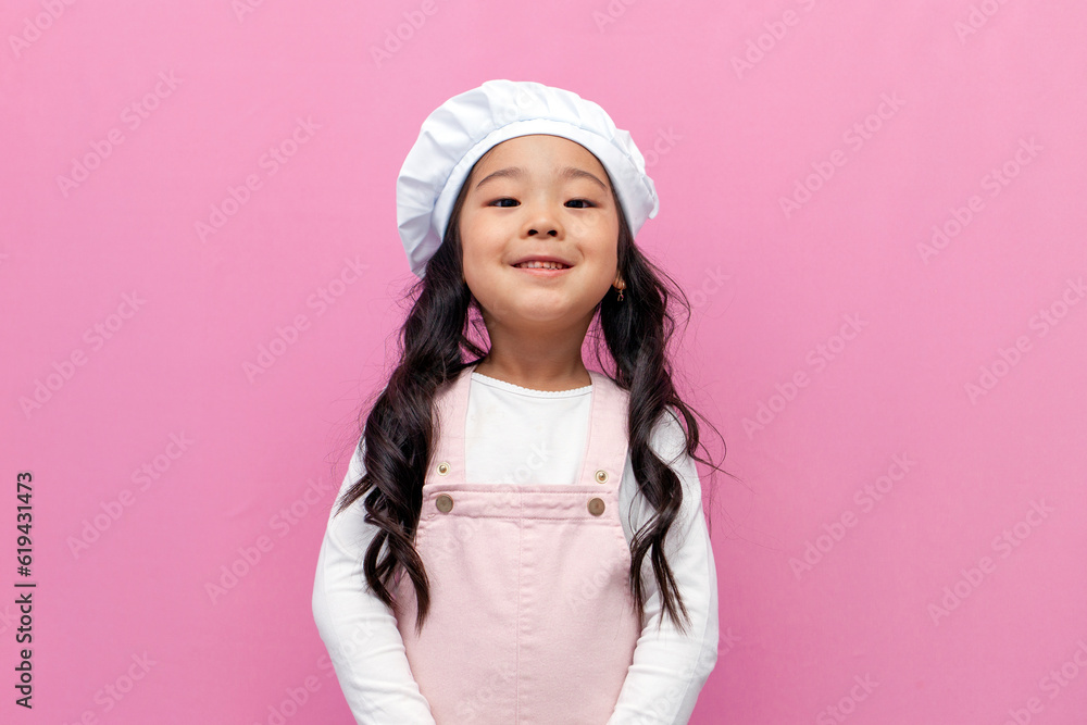 little asian girl in chef uniform smiling on pink isolated background, korean preschool child cook in apron little asian girl in chef uniform smiling on pink isolated background, korean preschool child cook in apron