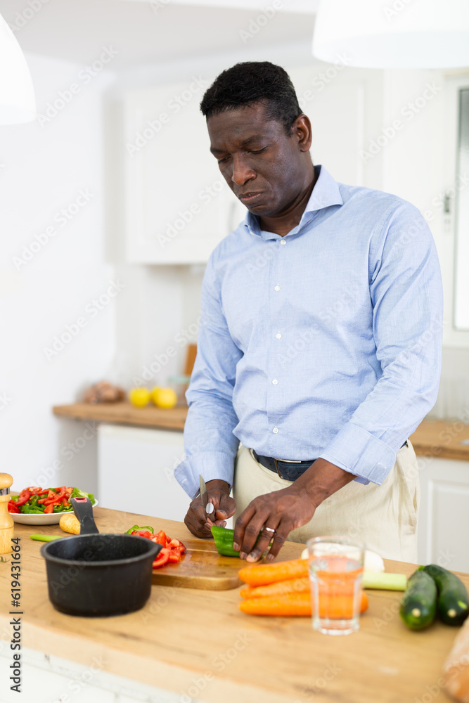 Man making dinner at kitchen table Man making dinner at kitchen table