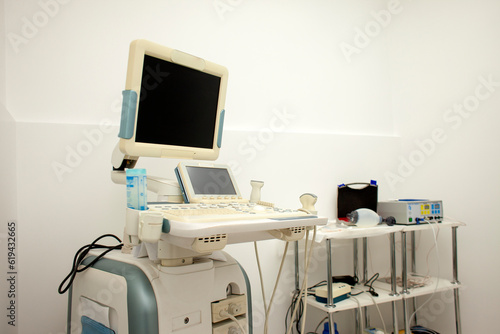 modern ultrasound machine in a hospital on a white background with a blank screen © Богдан Маліцький
