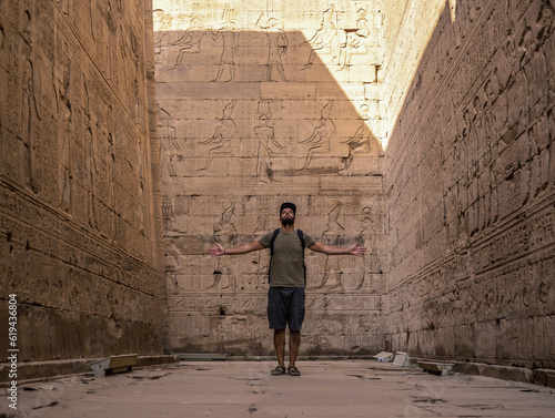 A young tourist visiting the beautiful temple of Edfu in the city of Edfu, Egypt. On the bank of the Nile river, geco-Roman construction, temple dedicated to Huros photo