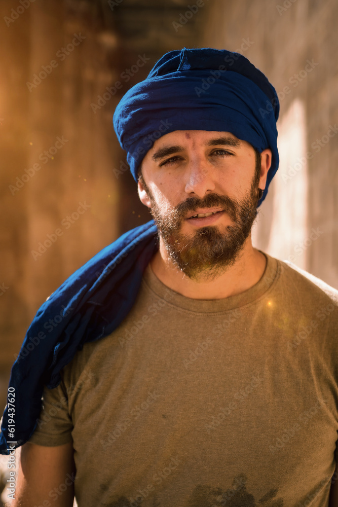 Young man in blue turban walking on the columns of the Edfu Temple near the city of Aswan. Egypt, west bank of the nile in the city of Edfu, Greco-Roman construction, dedicated to Horus Young man in blue turban walking on the columns of the Edfu Temple near the city of Aswan. Egypt, west bank of the nile in the city of Edfu, Greco-Roman construction, dedicated to Horus