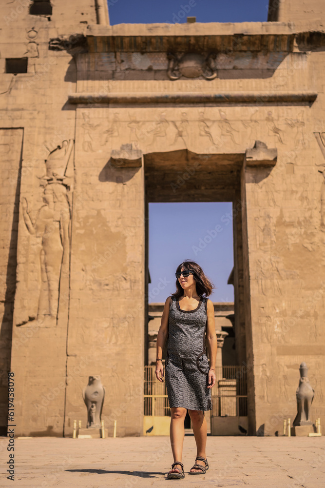 A young tourist at the entrance to the Edfu Temple near the Nile River in Aswan. Egypt, return of tourism in the coronavirus pandemic after 6 months stopped