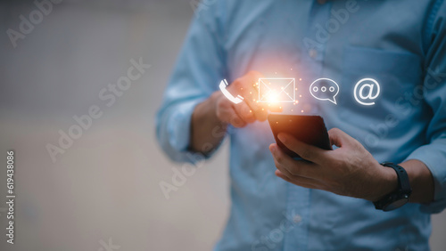 Businessman using Smart Phone with the email, call phone, address, Chat message icons.Customer support hotline Contact us people connection.