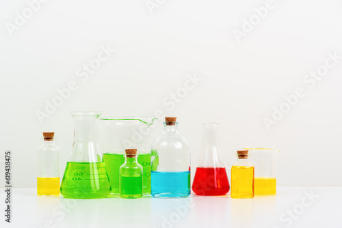 some test tube on the white table with beakers, flasks, and test tubes filled with colorful liquids