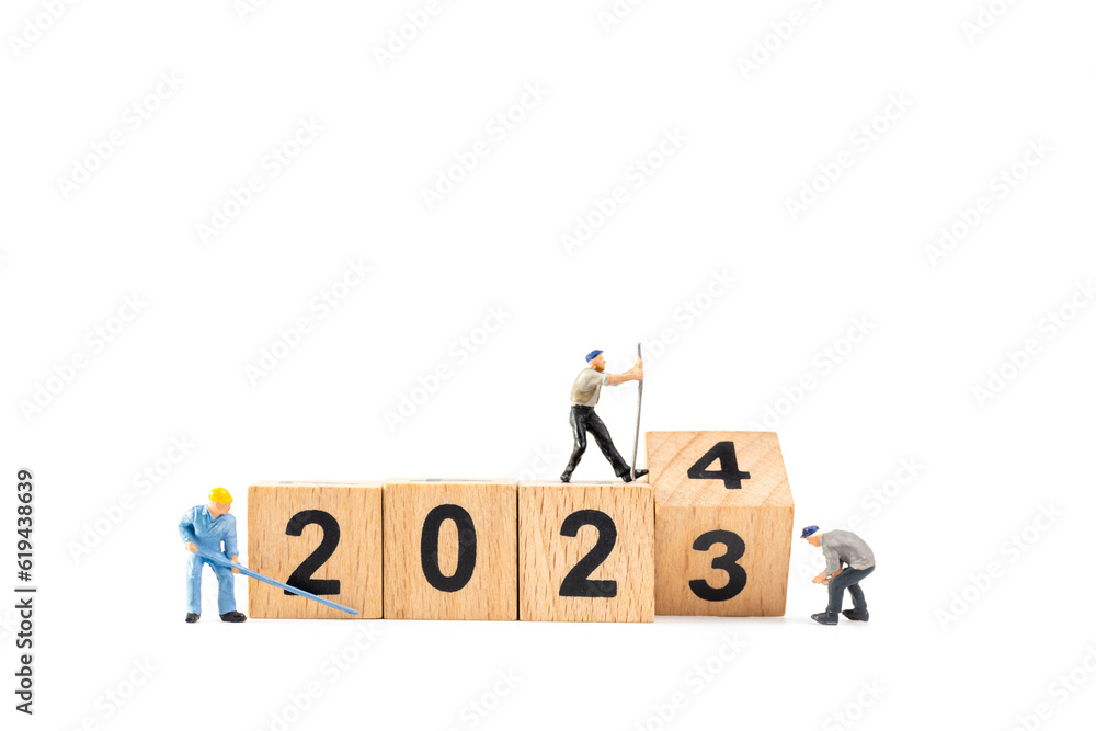 Miniature people , Worker team flips a wooden block with the number 2024