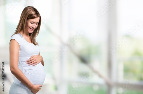 Portrait of young happy pregnant woman holding her belly © BillionPhotos.com