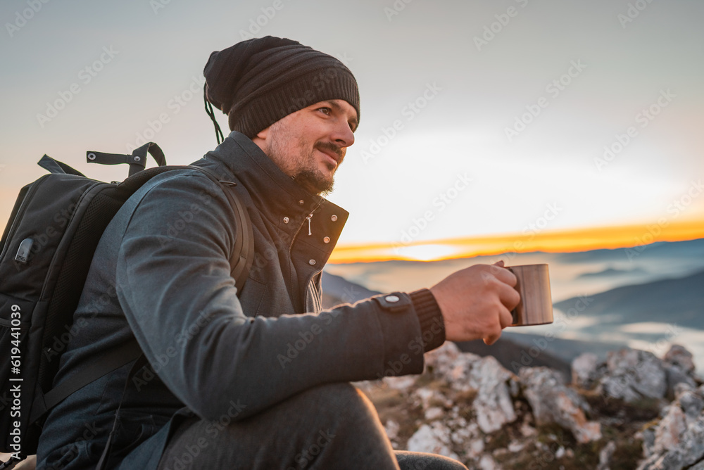 A happy man traveler drinking a cup of coffee during the hiking on the mountain. A happy man traveler drinking a cup of coffee during the hiking on the mountain.