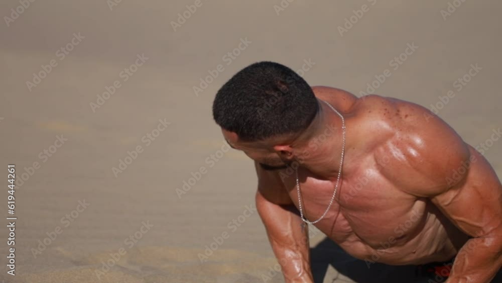 El cuerpo masculino perfecto - Impresionante culturista haciendo flexiones en la playa. Chico joven musculado en bañador. Espacio para texto	